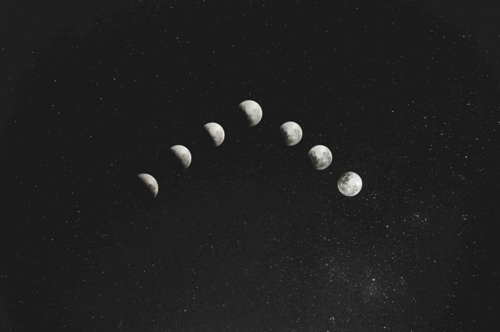 The Moon in the 1st house: meaning, effects & more – Born Under Saturn Moon depicted in all its phases in a dark blue sky adorned with stars.