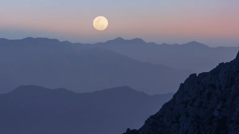 The Moon in the 10th house: meaning, effects & more Moon in the 10th house depicted by a shining full moon over the mountains.