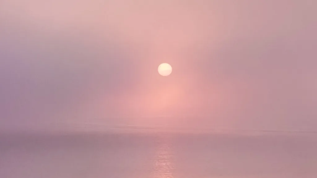 Moon in a pink sky to represent the Moon in the 12th house in a birth chart.
