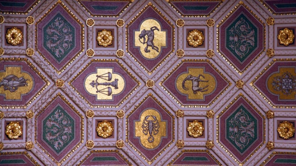 Vibrant purple and golden wall adorned with a beautifully drawn zodiac sign.