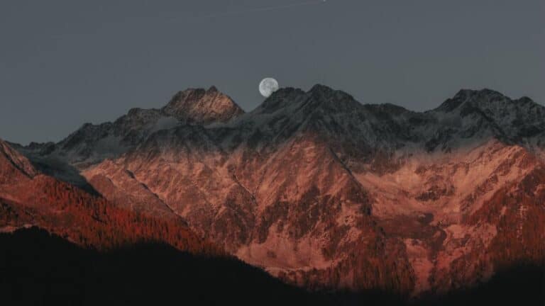 Black Moon Lilith in Scorpio represented by a full moon in a mountains landscape.
