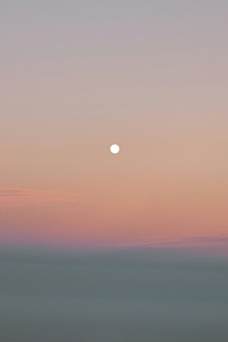 Gemini Full Moon 2025: Meaning, Rituals, Horoscope The Gemini Full Moon glowing in a pastel sky at dusk, against soft shades of peach, pink, and blue.