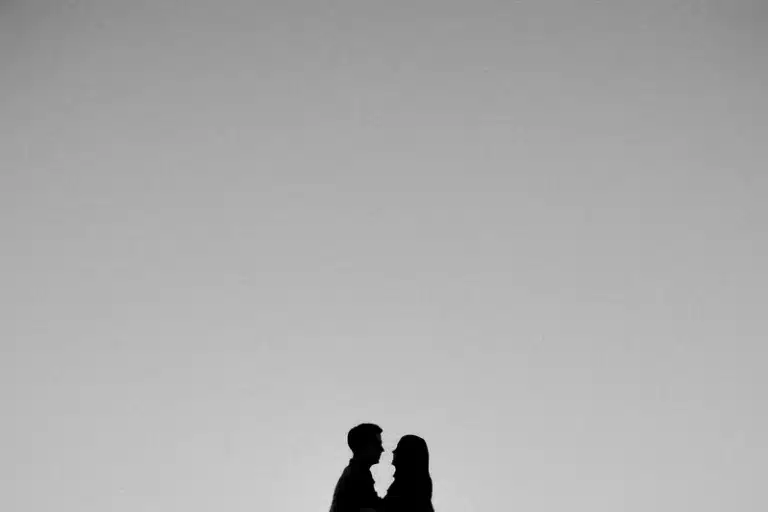 Rising Sign Compatibility in Love: Your Best Match(es) Rising sign compatibility represented by the silhouettes of two people facing each other beneath a vast grey sky.