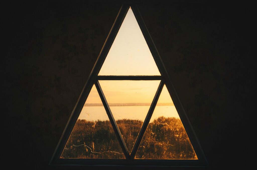 T square in astrology symbolized by a triangular window framing a horizon, representing tension, structure, and focused pressure within an astrological configuration.