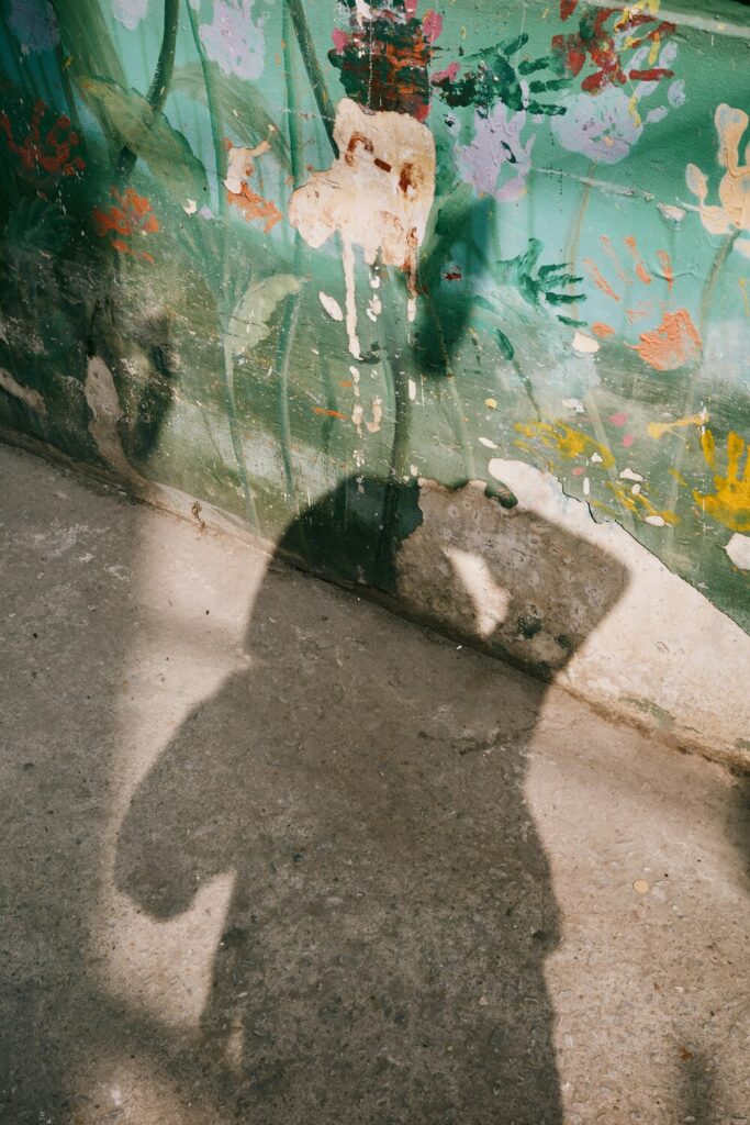 Aquarius Solar Eclipse symbolism, shadow of a person on a painted wall representing identity shift and self-reflection.