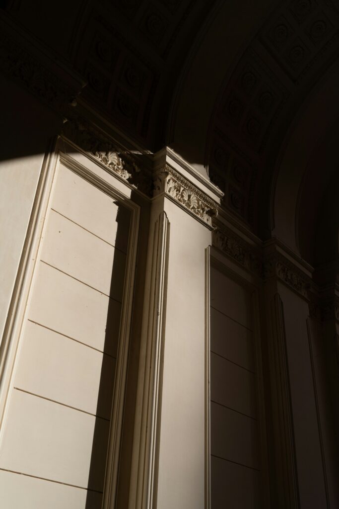 Aquarius Solar Eclipse symbolism, light and shadow on classical architecture suggesting change and new perspective.
