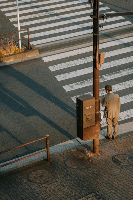 Neptune in the 6th house, lone person waiting at a crosswalk, symbolizing daily routines and work life.