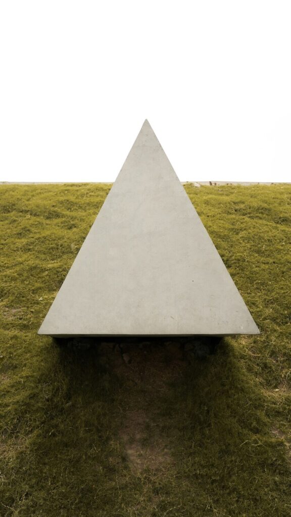 Trine aspect in astrology represented by a concrete triangular structure in a field.
