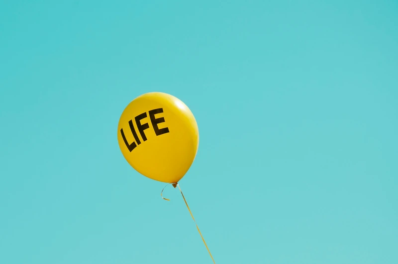Gemini season image of a balloon with the word “LIFE” floating against a light background, symbolizing curiosity, movement, and the playful, ever-changing nature of this season