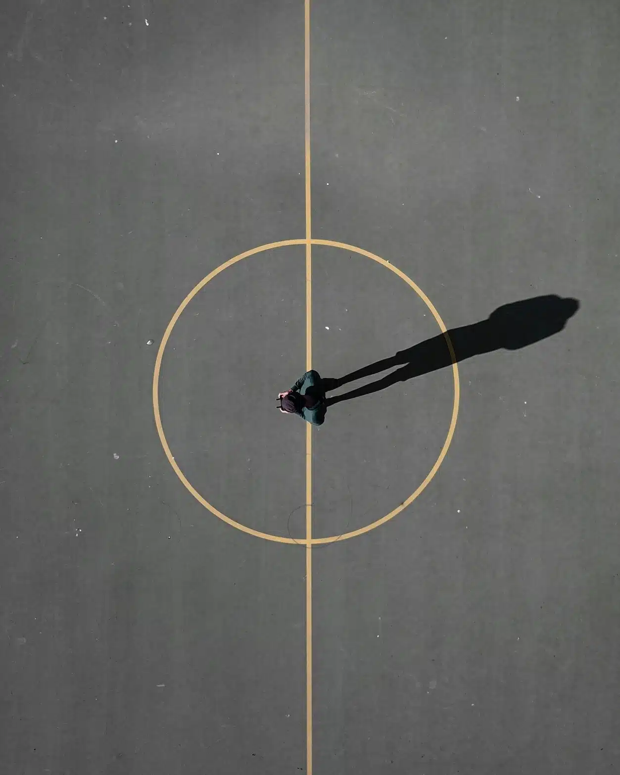 Horoscopes symbolism seen from above: a circular road with a man standing at the center, evoking the zodiac wheel.