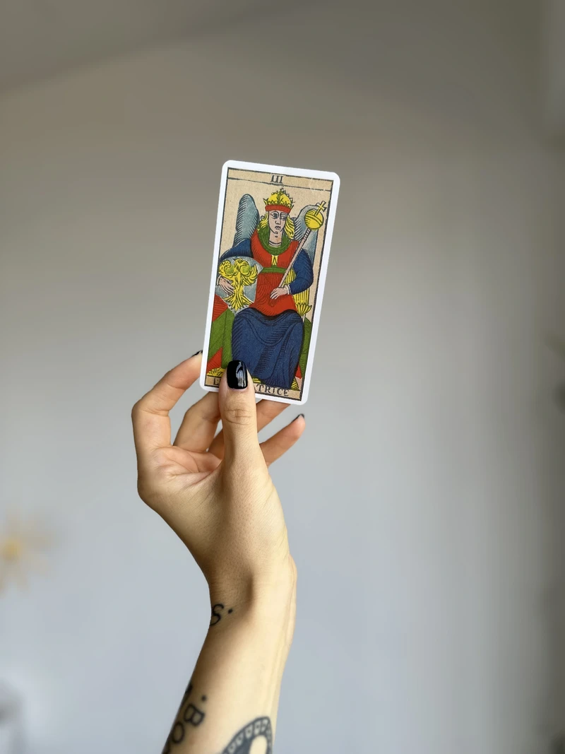 how to shuffle tarot cards hand holding a tarot card in a calm, focused moment before a reading