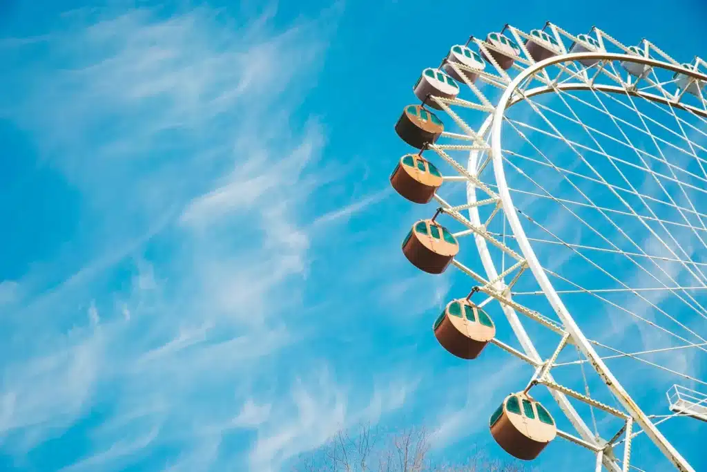 Neptune in the 7th House symbolism, ferris wheel against a blue sky representing idealism, shifting perspectives, and the dreamlike nature of relationships and partnerships.