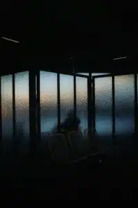 Taurus season grounding energy, dark window at sunset with warm light creating a calm atmosphere.