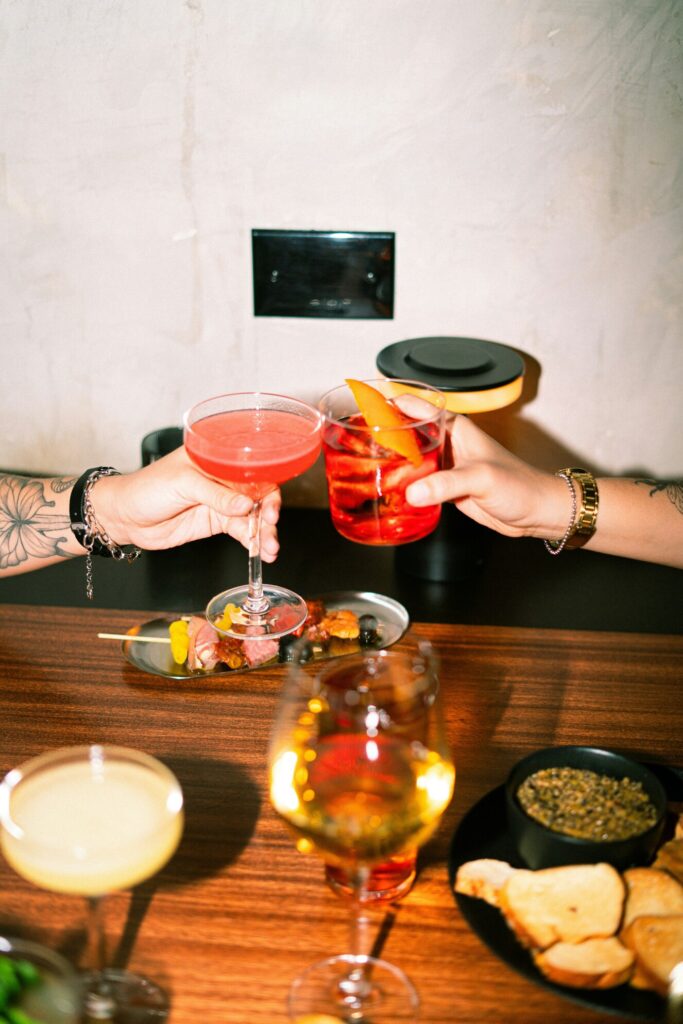 Venus in Taurus symbolism, two glasses clinking in a toast representing connection and shared pleasure.