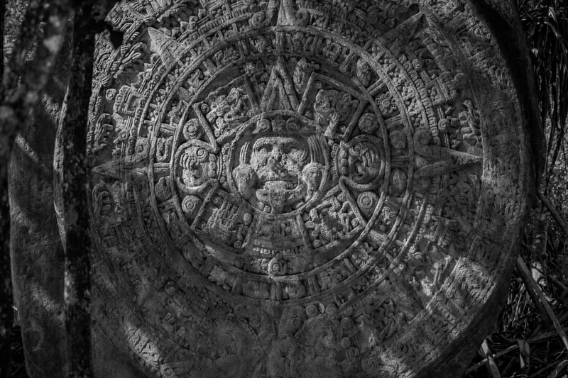 Mayan signs carved into an ancient Mayan calendar stone, black and white close-up showing detailed symbols of the sacred Tzolk'in.