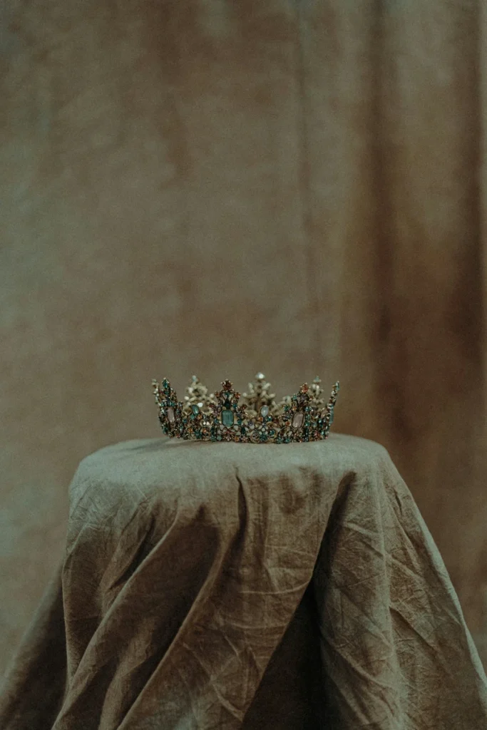leo rising symbolism crown on a table with a draped cloth, representing identity, presence, and quiet authority