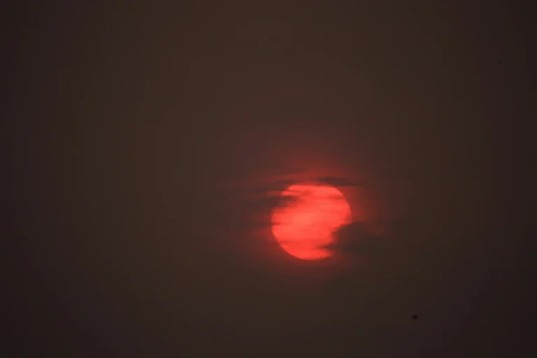 sagittarius full moon energy, deep red full moon in a dark night sky symbolizing intensity, truth, and emotional culmination