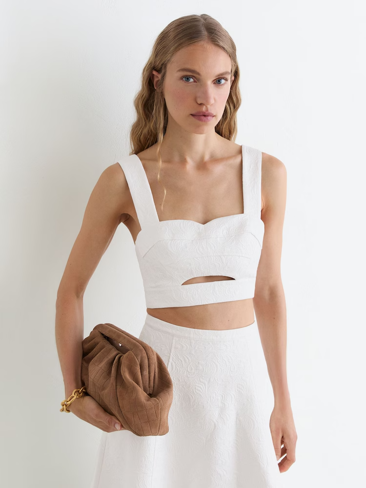 aquarius rising white top worn by a model, clean futuristic silhouette with minimalist and unconventional aesthetic