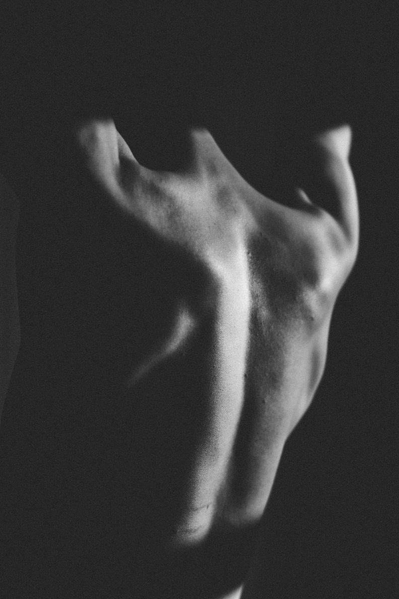 capricorn rising black and white photograph of a bare back, minimalist composition expressing strength, restraint, and quiet vulnerability