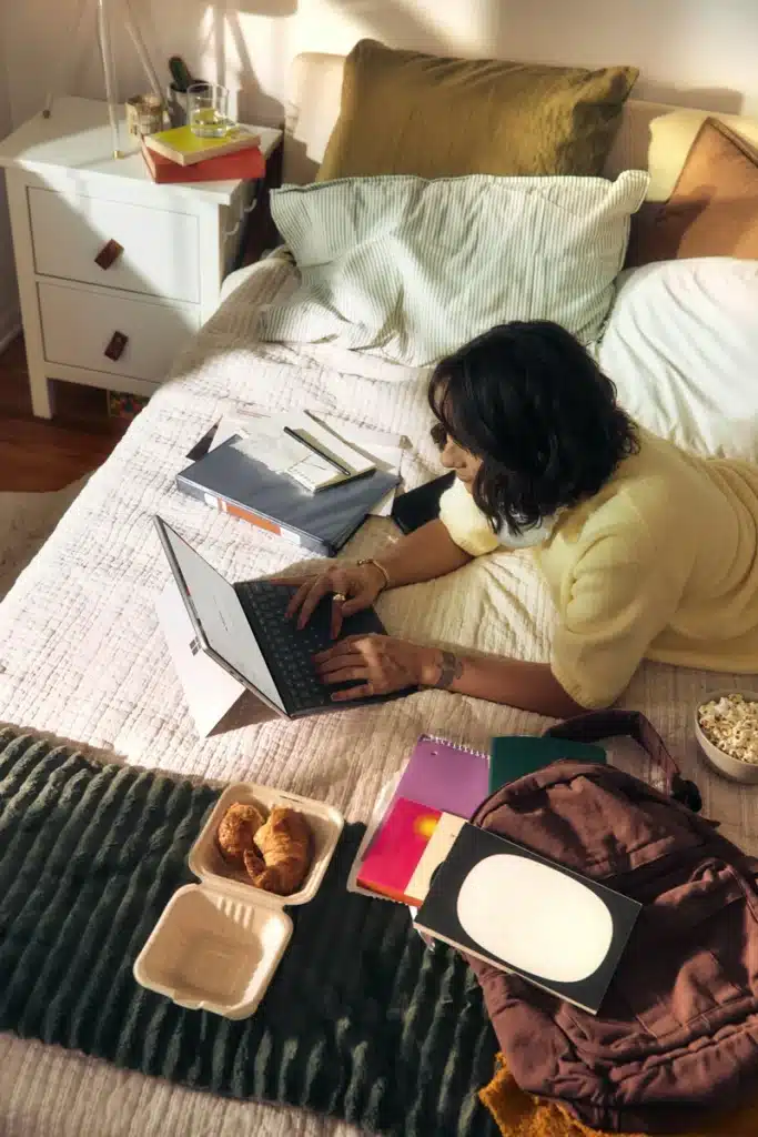mars in gemini, girl on a bed seen from above multitasking and writing on a tablet, symbolizing mental activity, restlessness, and fast-moving ideas