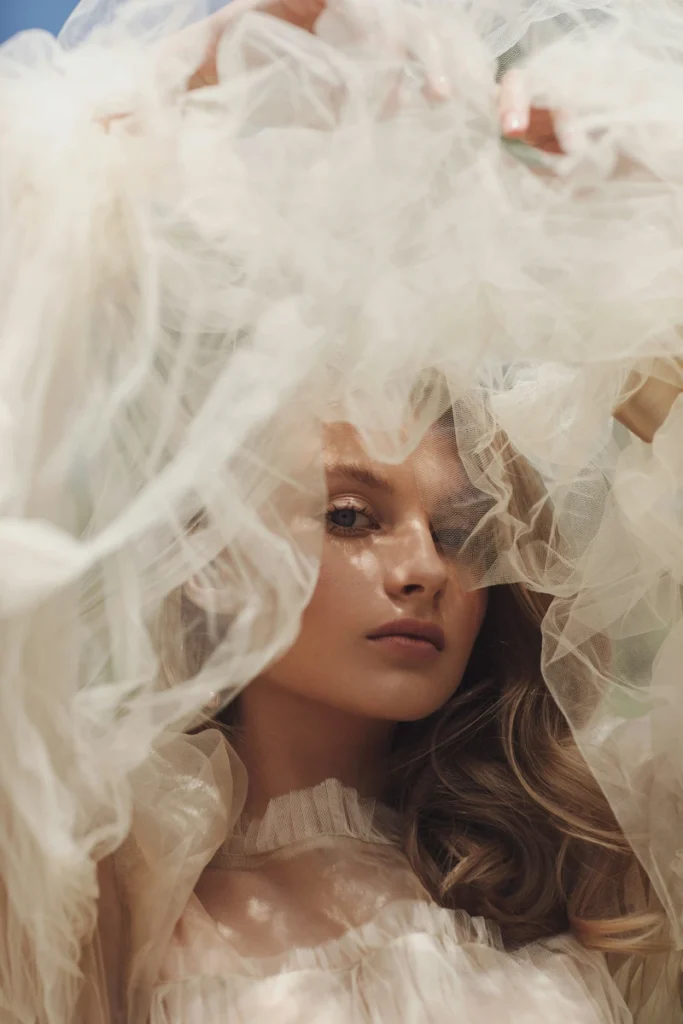 Pisces Rising: Meaning, Traits, Appearance & Personality pisces rising ethereal portrait of a woman surrounded by cloud-like fabric, dreamy emotional atmosphere with soft mystical and poetic aesthetic