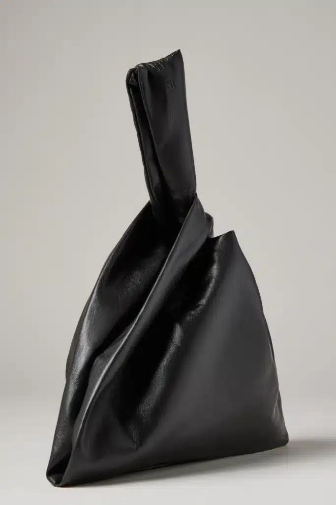 scorpio rising black vegan leather bag with knotted handle, structured silhouette and dark refined aesthetic expressing mystery and elegance