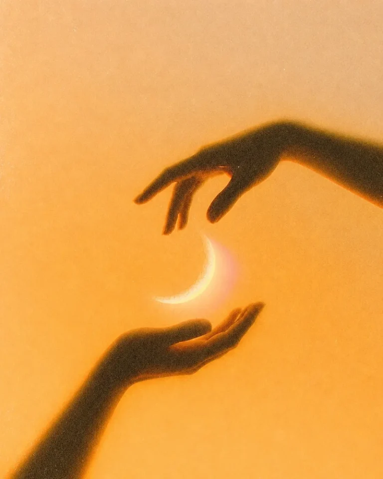 Cancer New Moon: Meaning, Manifestation, Horoscope New Moon in Cancer meaning symbolized by a glowing crescent moon held between two silhouetted hands against a warm golden background, evoking emotional renewal, protection, and inner belonging.