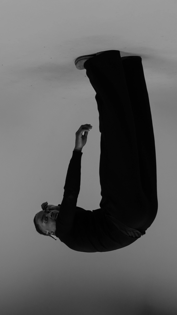 Eccentric astrology placements and aspects symbolized by a black-and-white upside-down image of a person hanging headfirst, representing the outsider archetype and a different way of seeing reality.