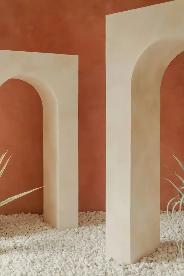 Venus in Virgo transit symbolized by minimal architectural arches on a quiet red wall, evoking refined beauty, silence, balance, and love expressed through careful simplicity.