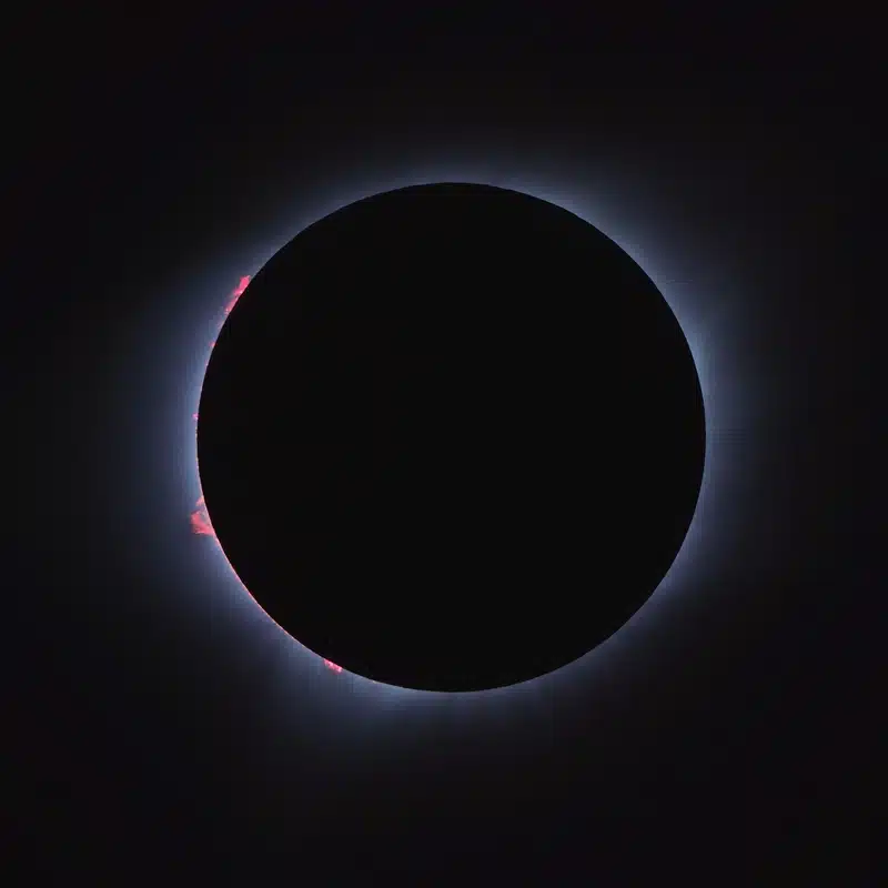 Lunar eclipse in Pisces 2026 image showing a dark eclipsed Moon surrounded by a pale blue corona against a black sky.