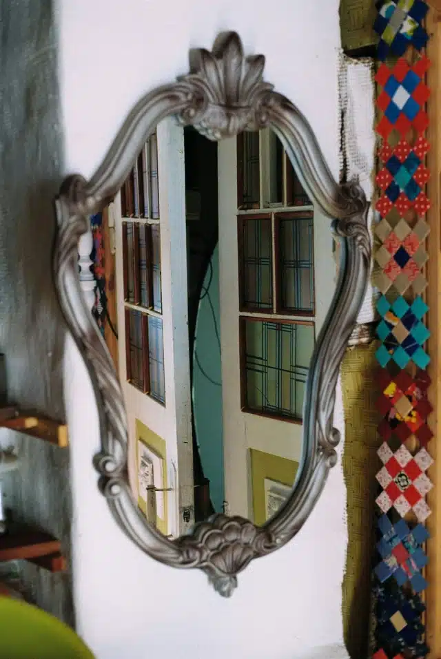 Venus enters Libra image with an ornate vintage mirror reflecting a doorway and windows, symbolizing beauty, balance, and relationship as reflection.