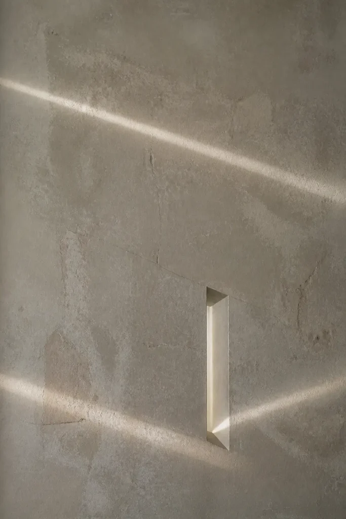 A narrow beam of light entering through an opening in a textured wall, symbolising the clarity offered by a one question astrology reading.