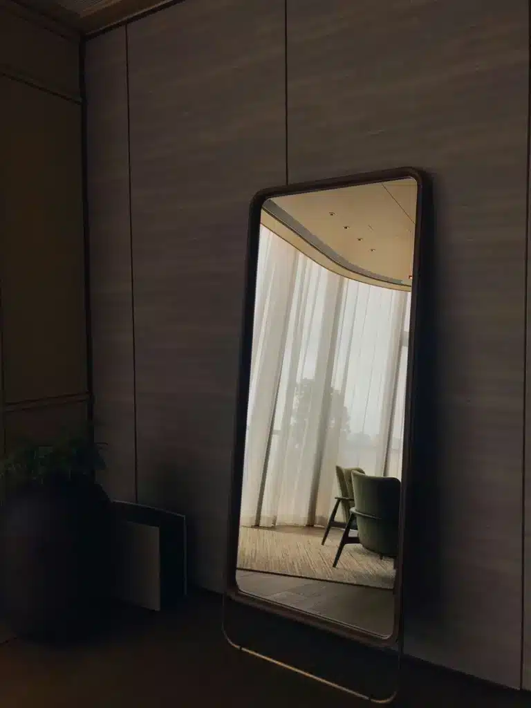 Libra New Moon image with a large mirror reflecting soft curtains and a quiet interior, symbolizing reflection, balance, beauty, and new beginnings.