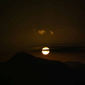 Aquarius Solar Eclipse on February 17, 2026 over dark mountains.