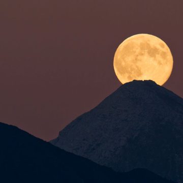 Moon appearing behind the mountain top.