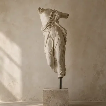 Full Moon in Taurus image with a classical headless statue on a stone pedestal against a warm wabi sabi wall, evoking grounding, stillness, beauty, and earthy stability.