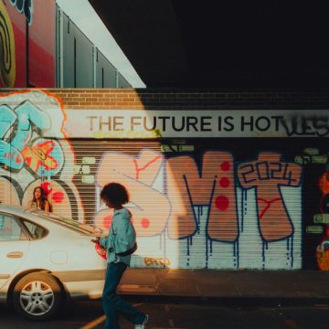 Questions to ask tarot cards reflected through urban street art reading “The future is hot,” symbolizing introspection and personal insight.