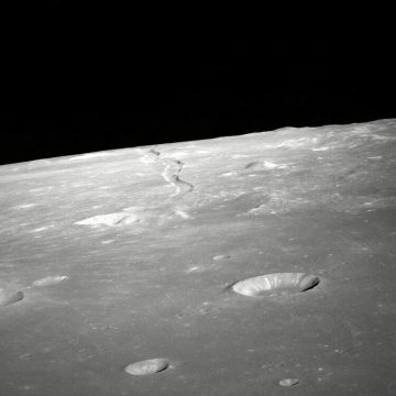 Moon surface with craters and shadowed horizon.
