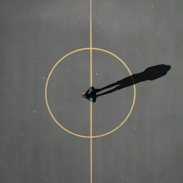 Horoscopes symbolism seen from above: a circular road with a man standing at the center, evoking the zodiac wheel.