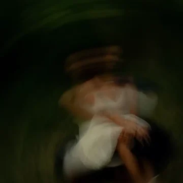 Jupiter in Leo dark abstract motion image with blurred woman in white dress ethereal luminous presence