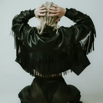 Mars in Aries energy symbolized by a woman seen from behind wearing a black leather jacket, representing courage, strength, and bold action.