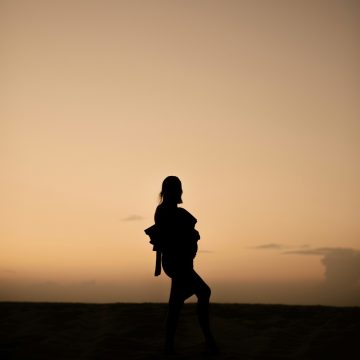 Mars in Sagittarius – silhouette of a person standing under a golden sunset sky, symbolizing vision, freedom, and movement.