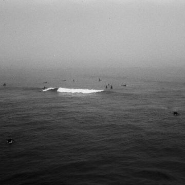 Pisces Lunar Eclipse symbolized by surfers on the ocean, reflecting the water moon’s energy.