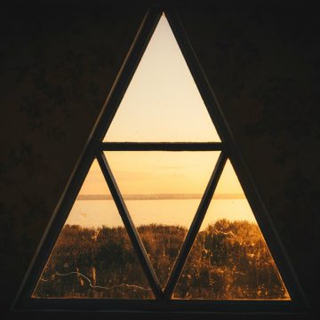 T square in astrology symbolized by a triangular window framing a horizon, representing tension, structure, and focused pressure within an astrological configuration.