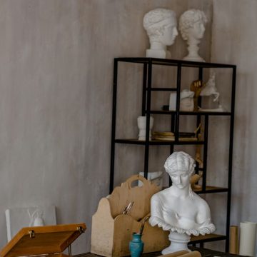Aquarius season atmosphere with classical bust, art tools, and future-minded creative space
