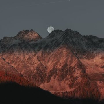 Black Moon Lilith in Scorpio represented by a full moon in a mountains landscape.