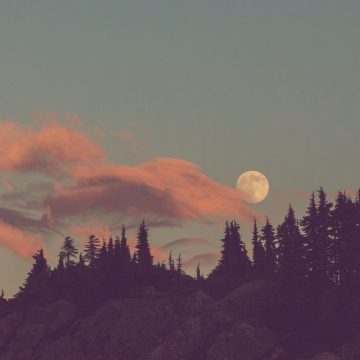 Moon in the sixth house represented by a full moon in a stunning landscape.