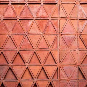 Trine aspect in astrology represented by a terracotta wall with a repeating triangle pattern.